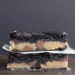 Two stacked fudge brownie bars layered with cookie dough and chocolate chips.